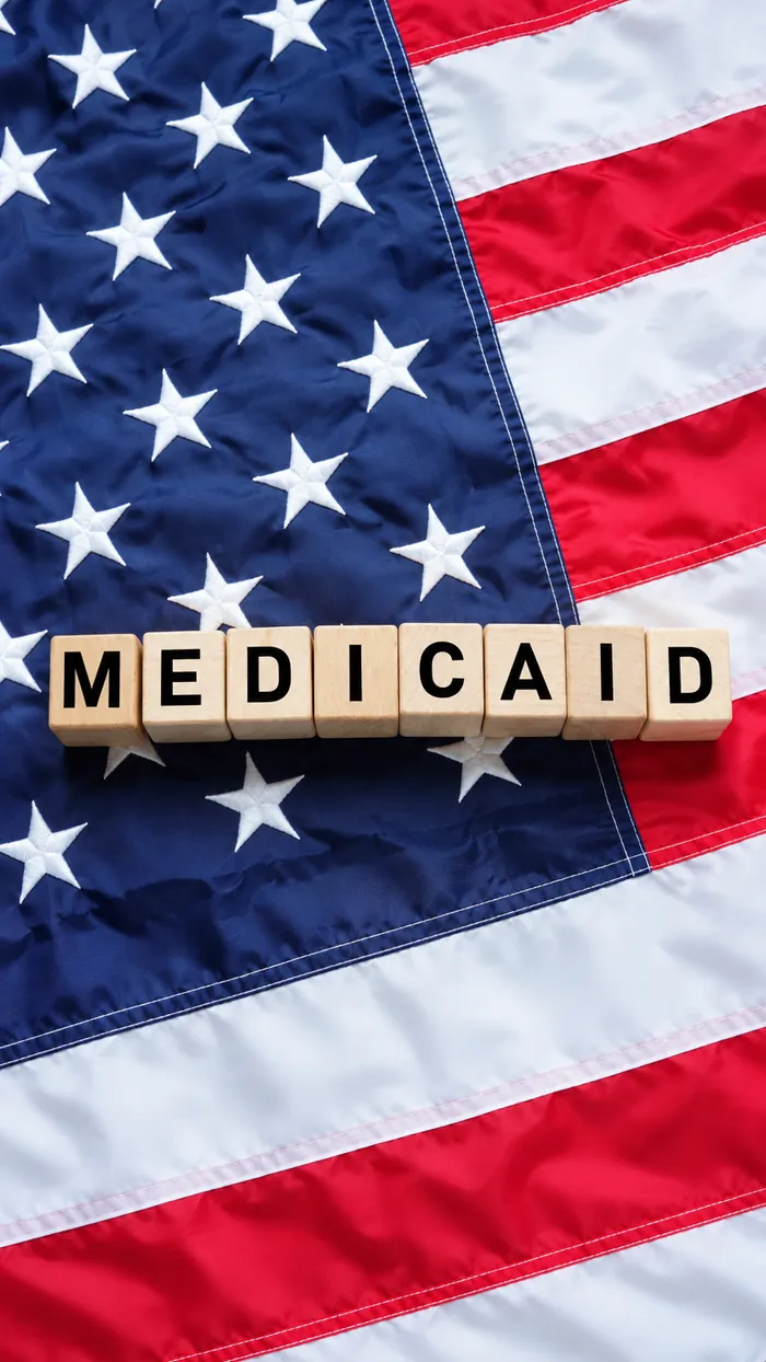 Wooden blocks spelling Medicaid on a U.S. flag